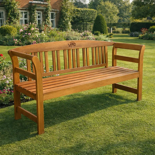 Rose-engraved wooden garden bench on a lawn in a traditional garden.