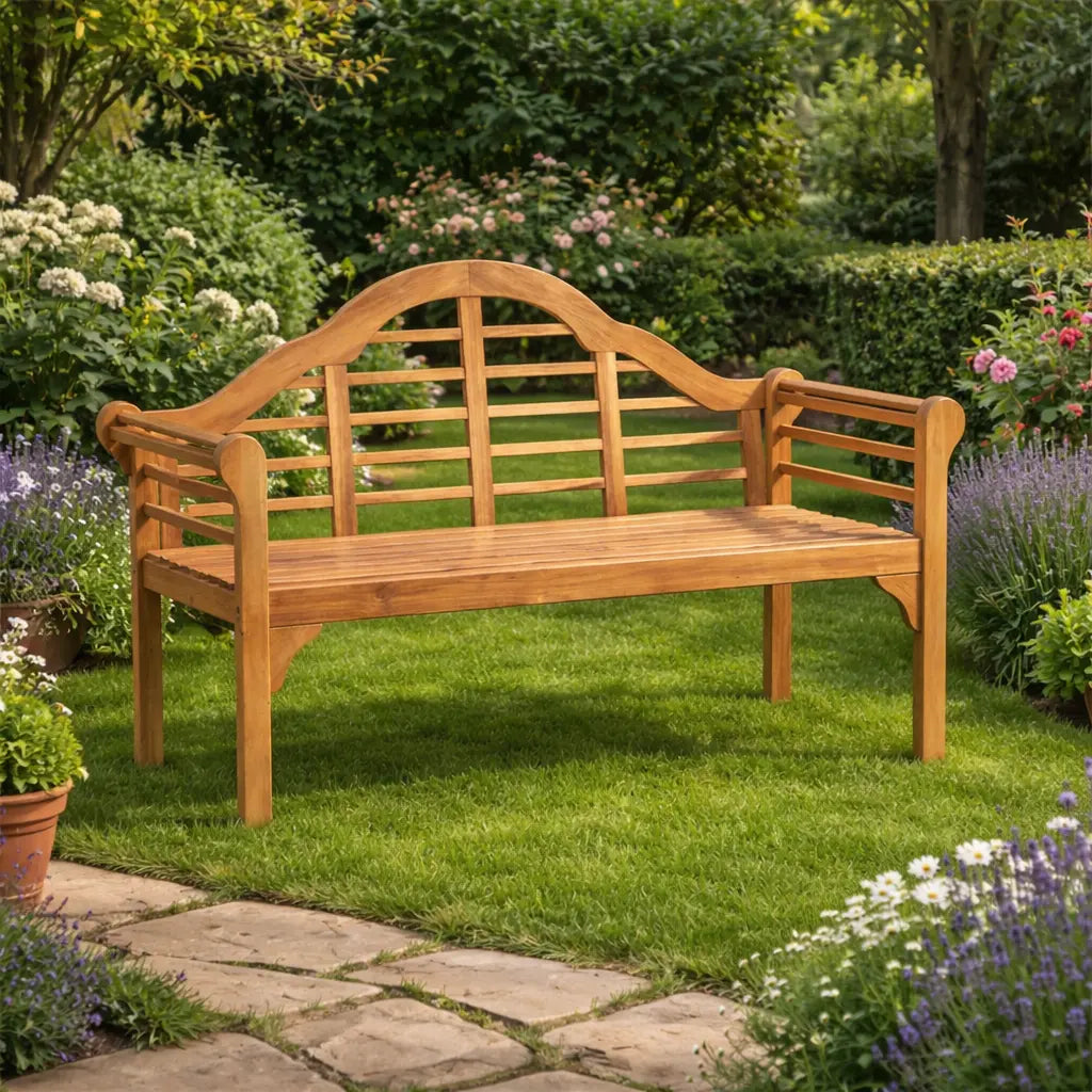 Traditional wooden garden bench placed on a green lawn surrounded by lavender and flowering shrubs in a classic garden setting